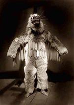 Ceremonial dancer, full-length portrait, standing, wearing mask and a fur garments during the Winter Dance ceremony.
