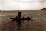 Three people in canoe with sail British Columbia.