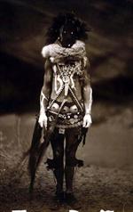 Nayenezgani, a Navajo deity, full-length portrait, facing front, wearing body paints and other adornments.